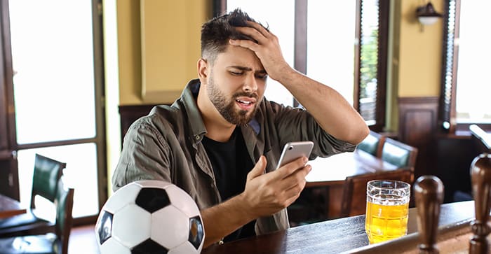 Barで嘆く人とサッカーボールの画像